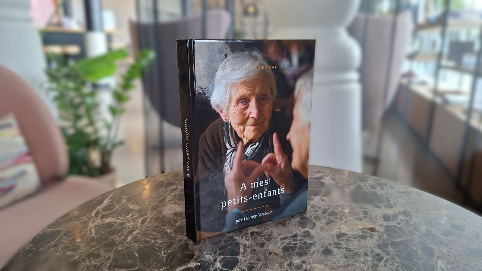 La Grande Biographie, livre relié à couverture rigide, posé debout sur une table
